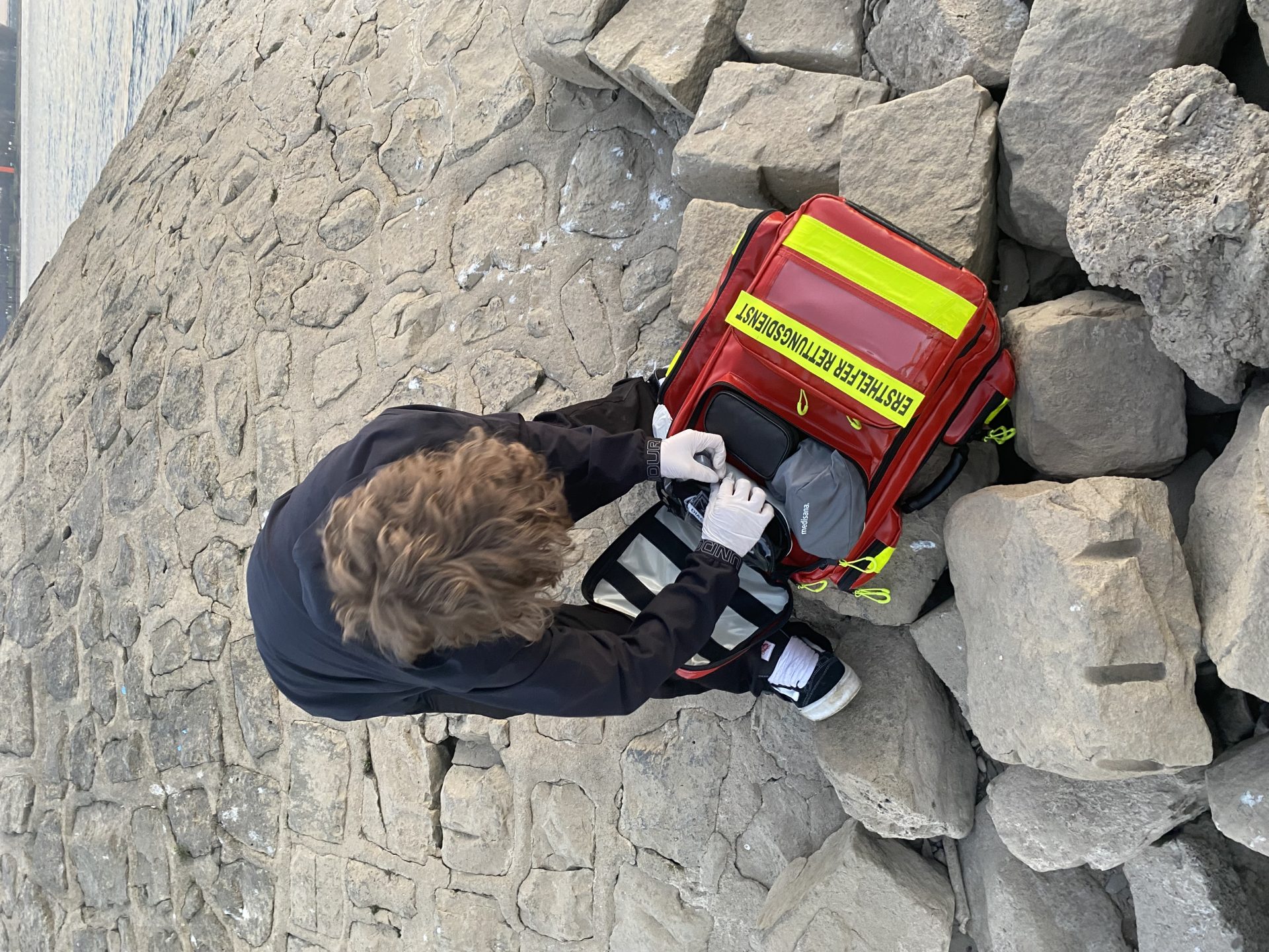 Junge mit Notfalltasche am Ufer